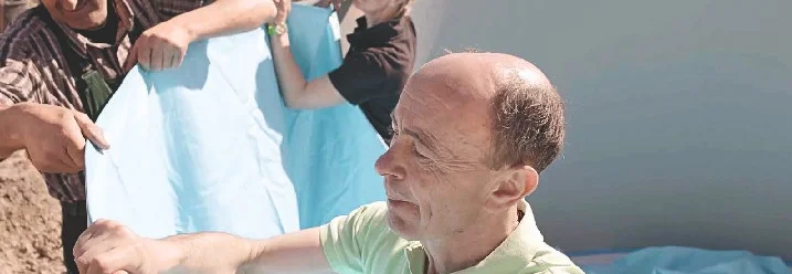 Drei Personen bringen Poolfolie an